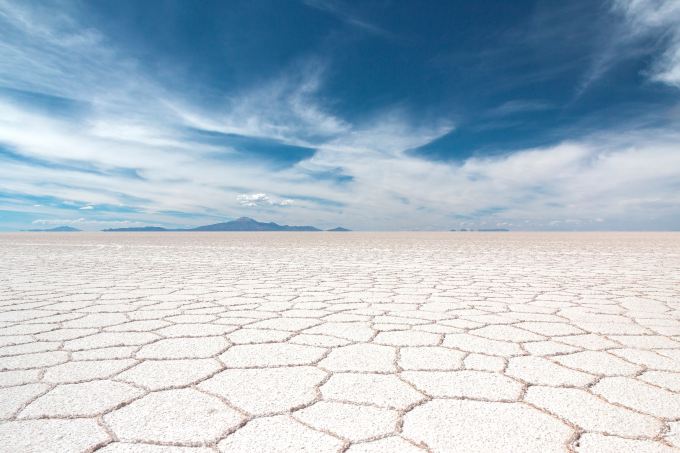 Cracked salt flats under a blue sky.