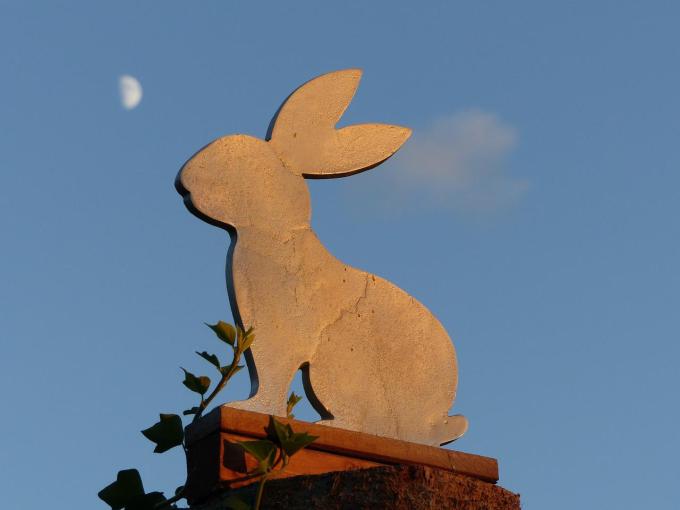 Metal rabbit silhouette with a half moon in the background