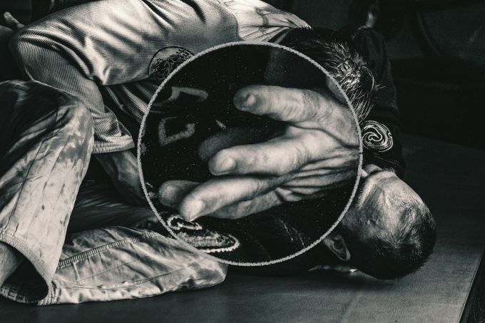 Two people in a jiujitsu grapple.