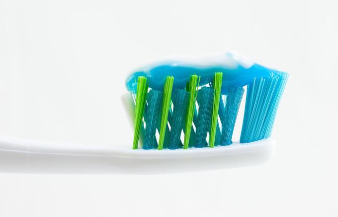 Blue toothpaste on the head of a toothbrush