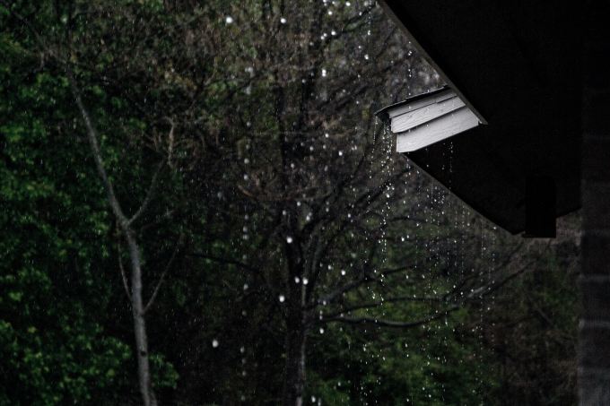 Rain falling from the edge of a roof.