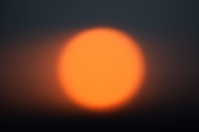 A blurry orange orb over a black background