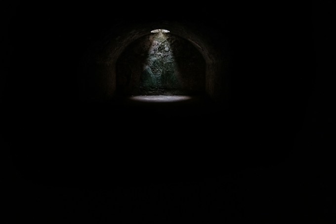Spotlight coming from a hole above a tunnel
